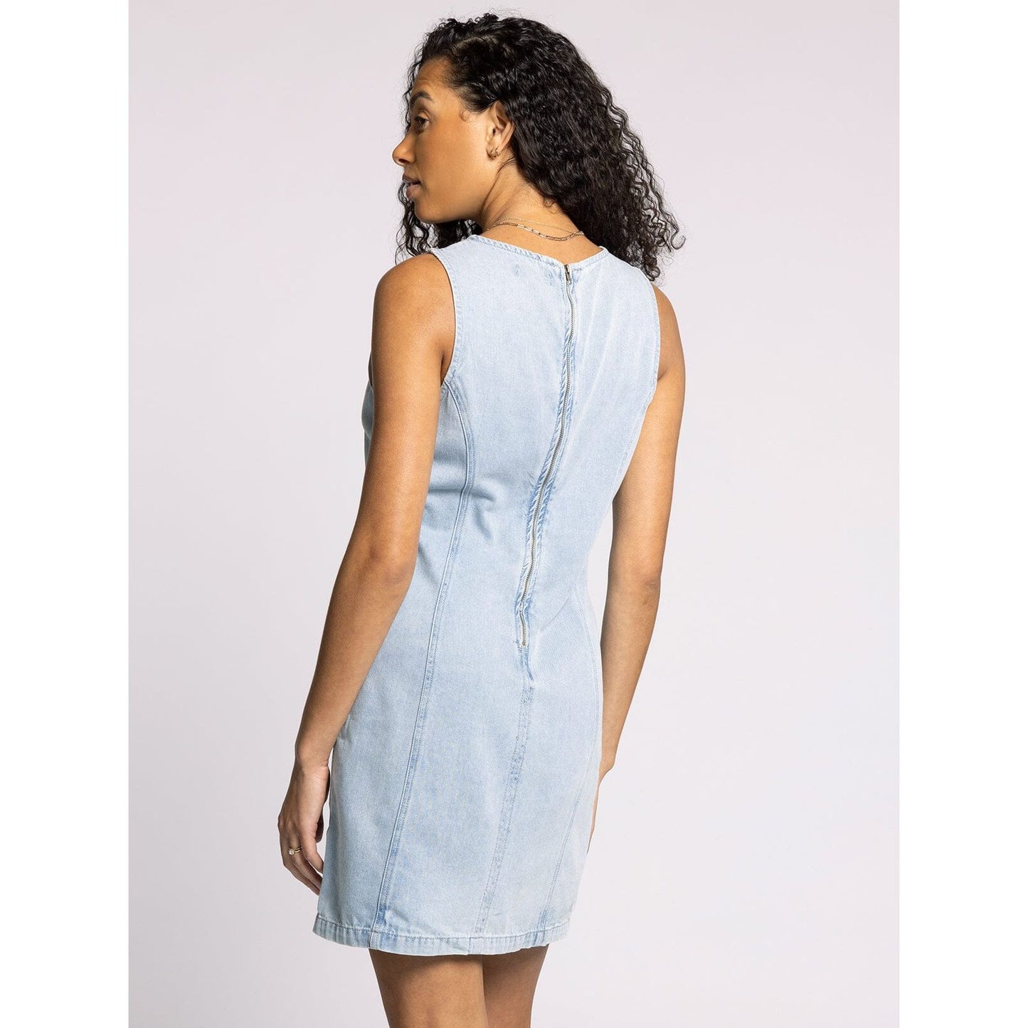 Light blue denim dress worn by a person on a white background