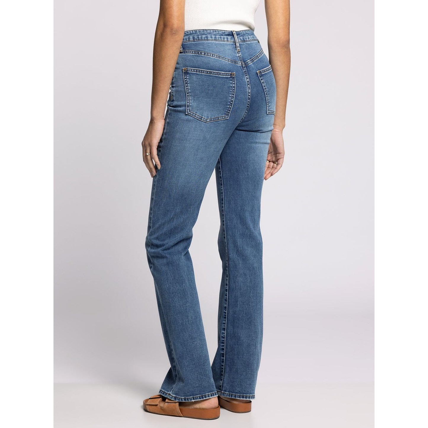 Blue jeans worn by a person on a white background