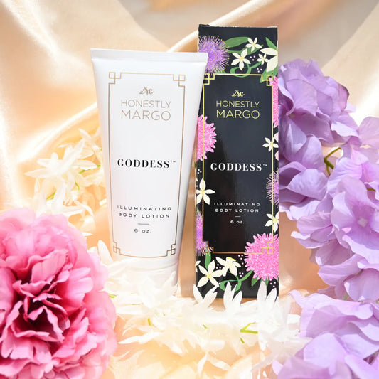 Honestly Margo Goddess illuminating body lotion with packaging surrounded by flowers on a soft background