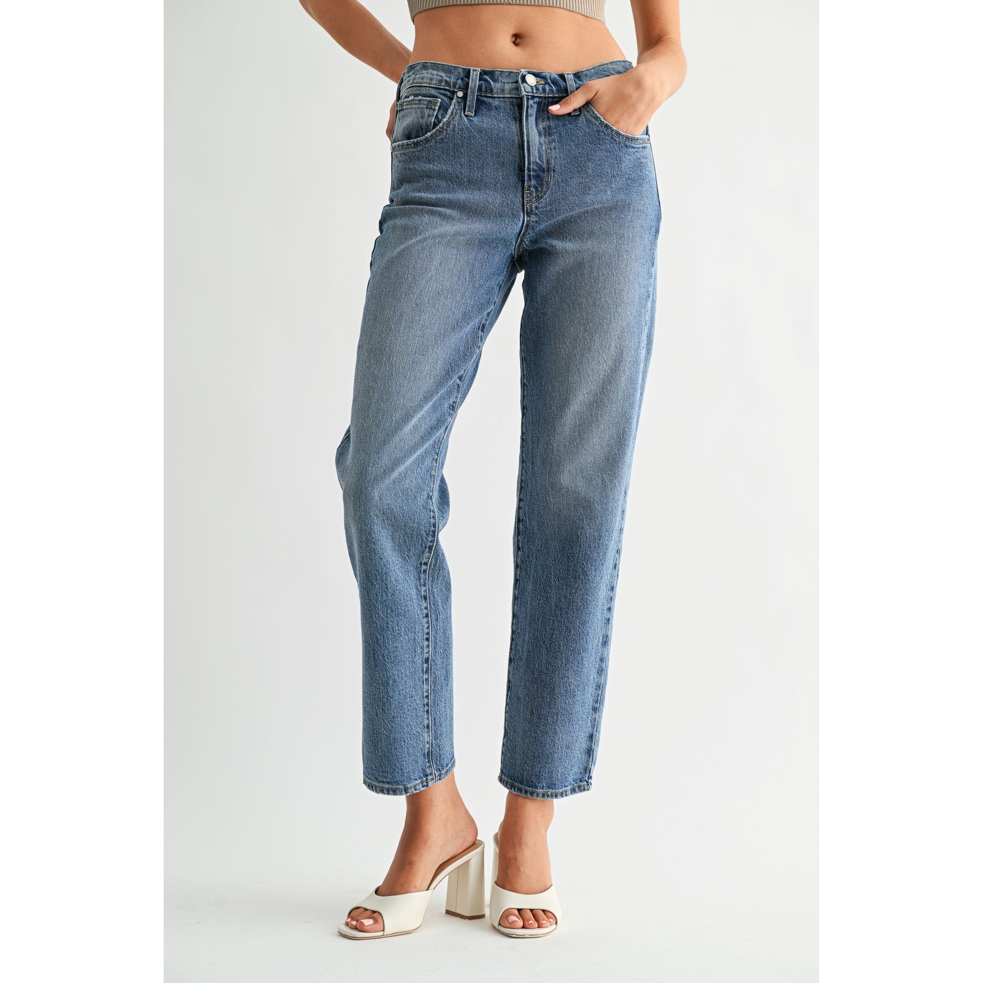 Person wearing blue jeans on a plain background