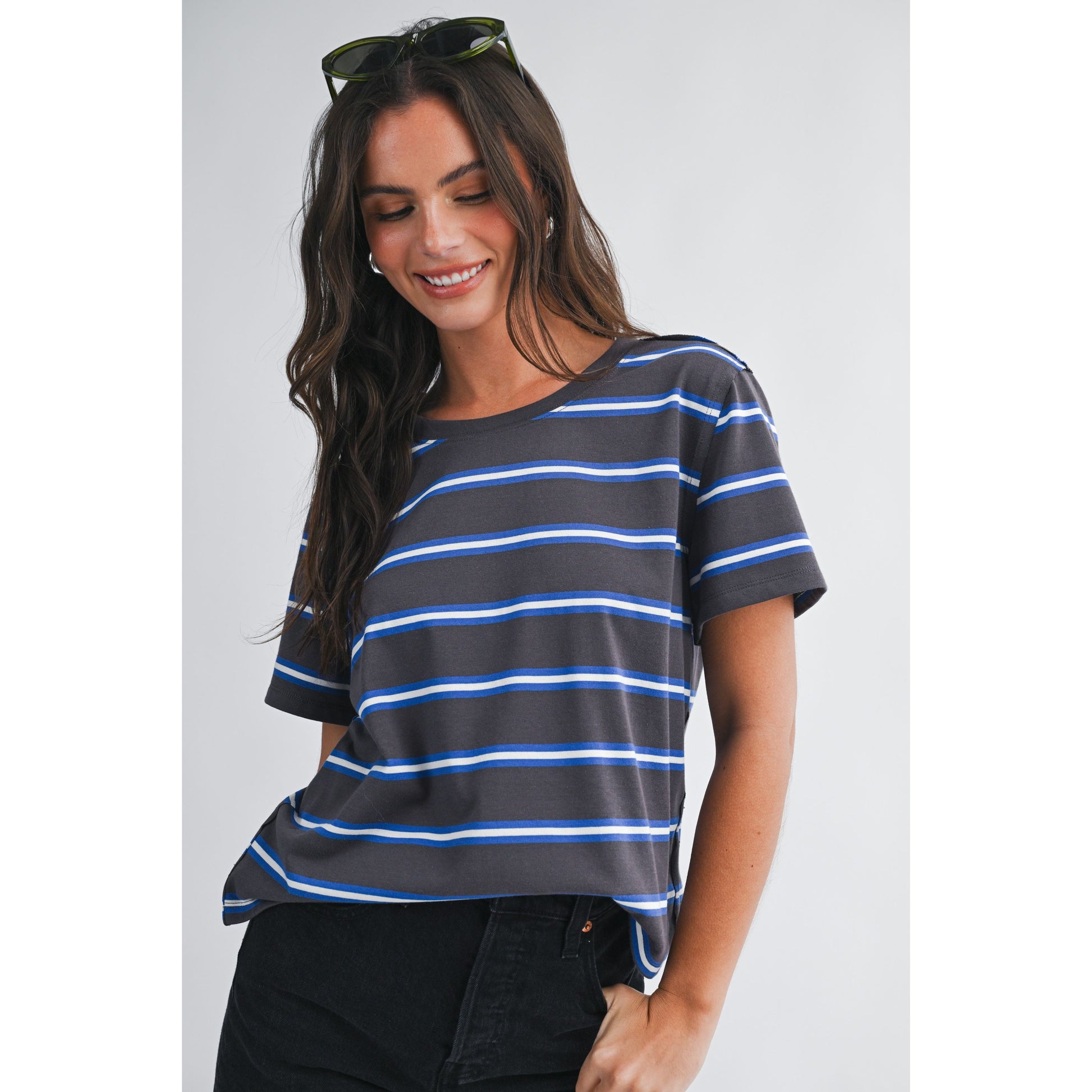Woman wearing a black and blue striped t-shirt against a plain background