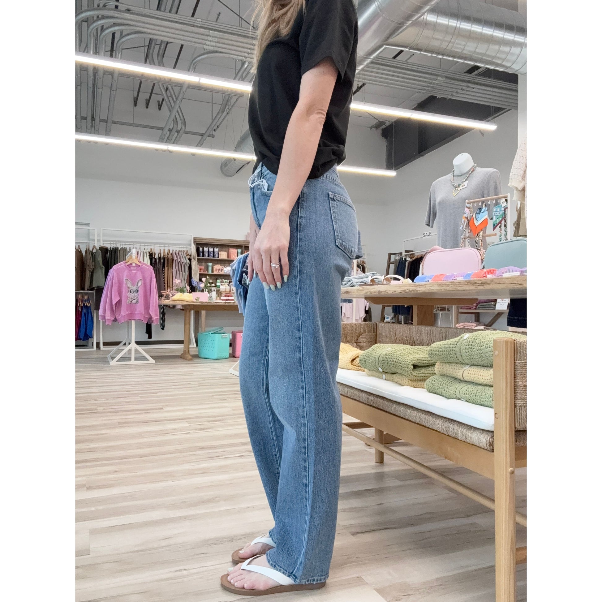 Person wearing blue jeans and a black shirt in a store setting