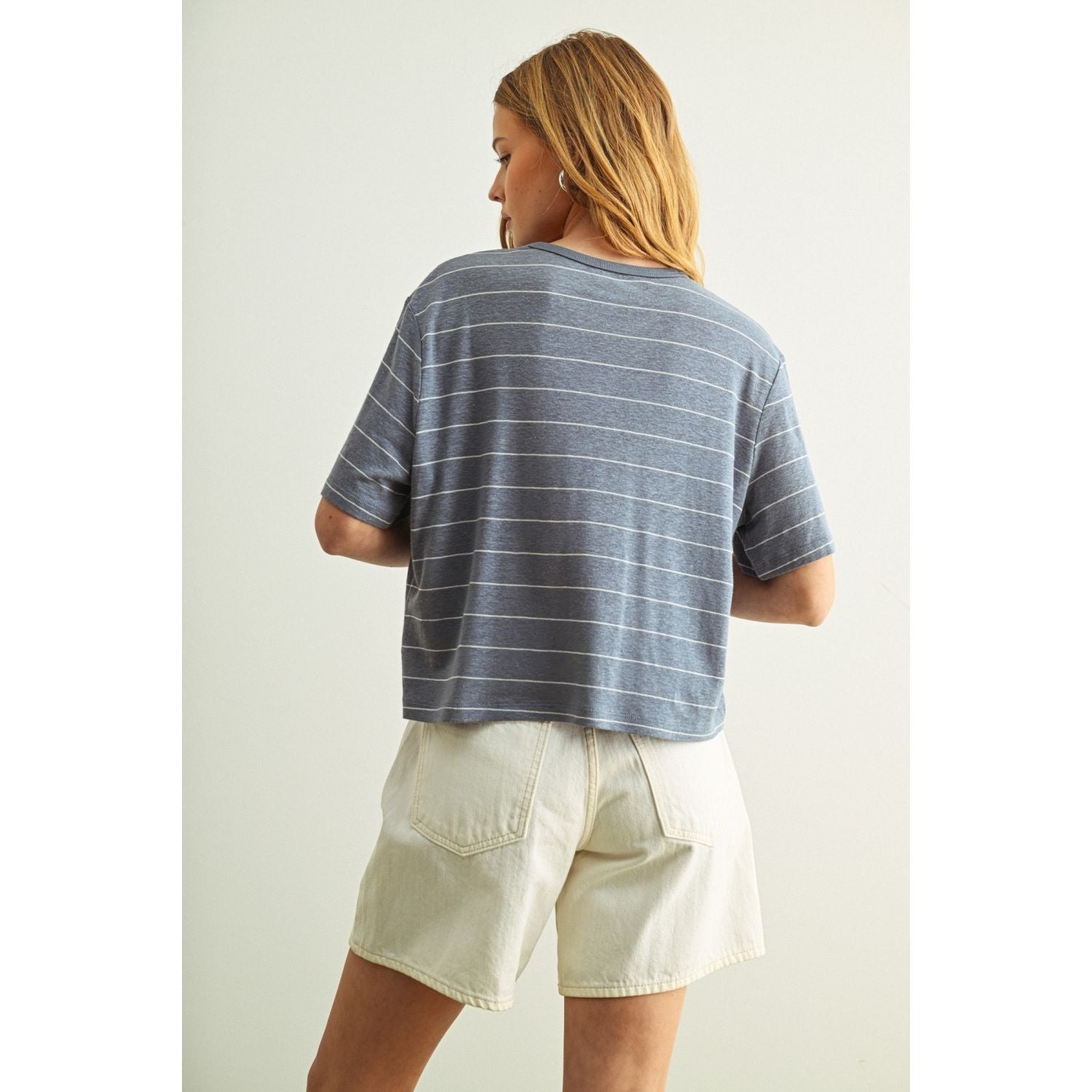 Back view of a woman wearing a blue tee with thin white stripes