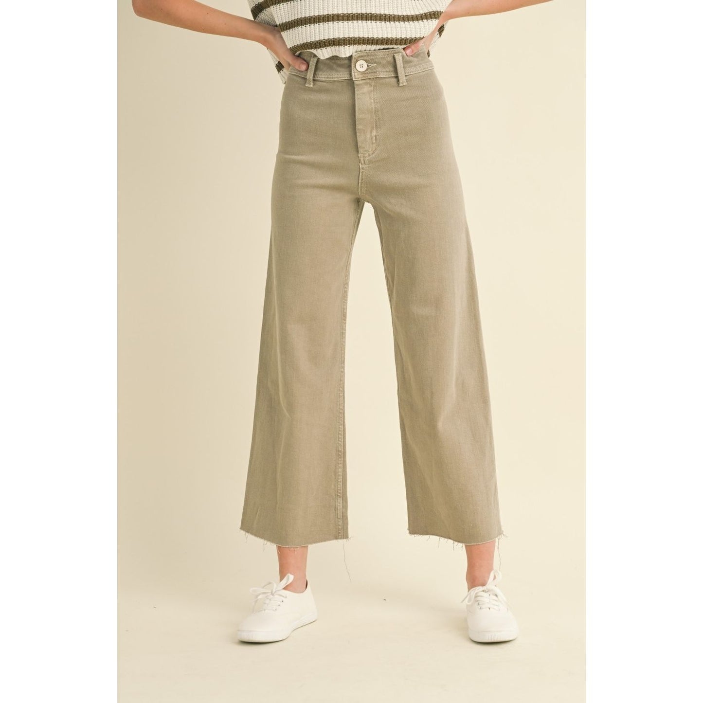 Person wearing stone color wide-leg jeans with a frayed hem