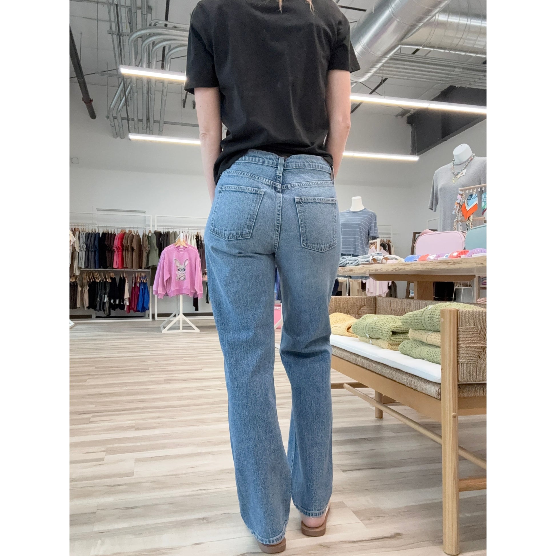 Person wearing blue jeans and a black shirt in a store setting