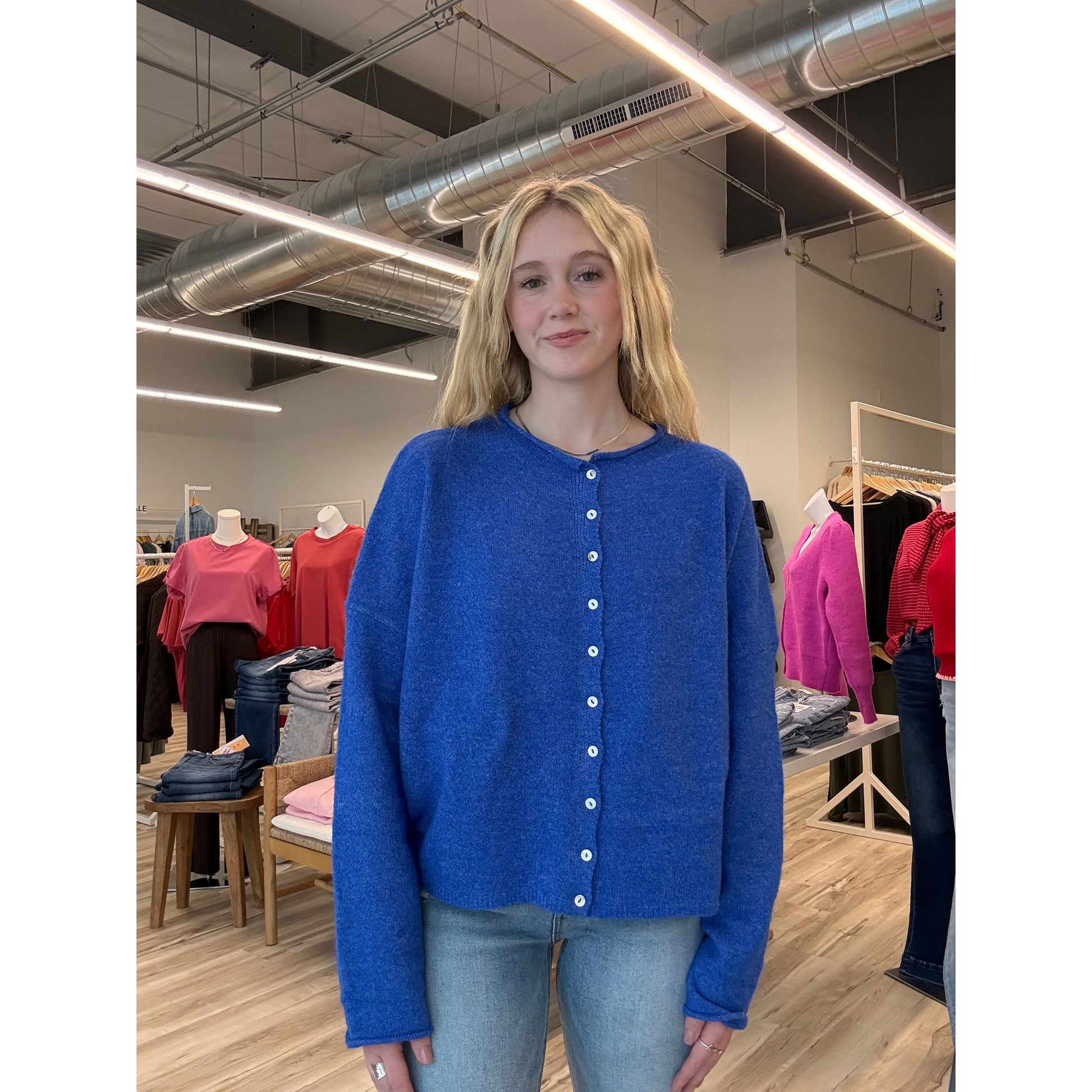 Person wearing a blue coat with white buttons in a store setting