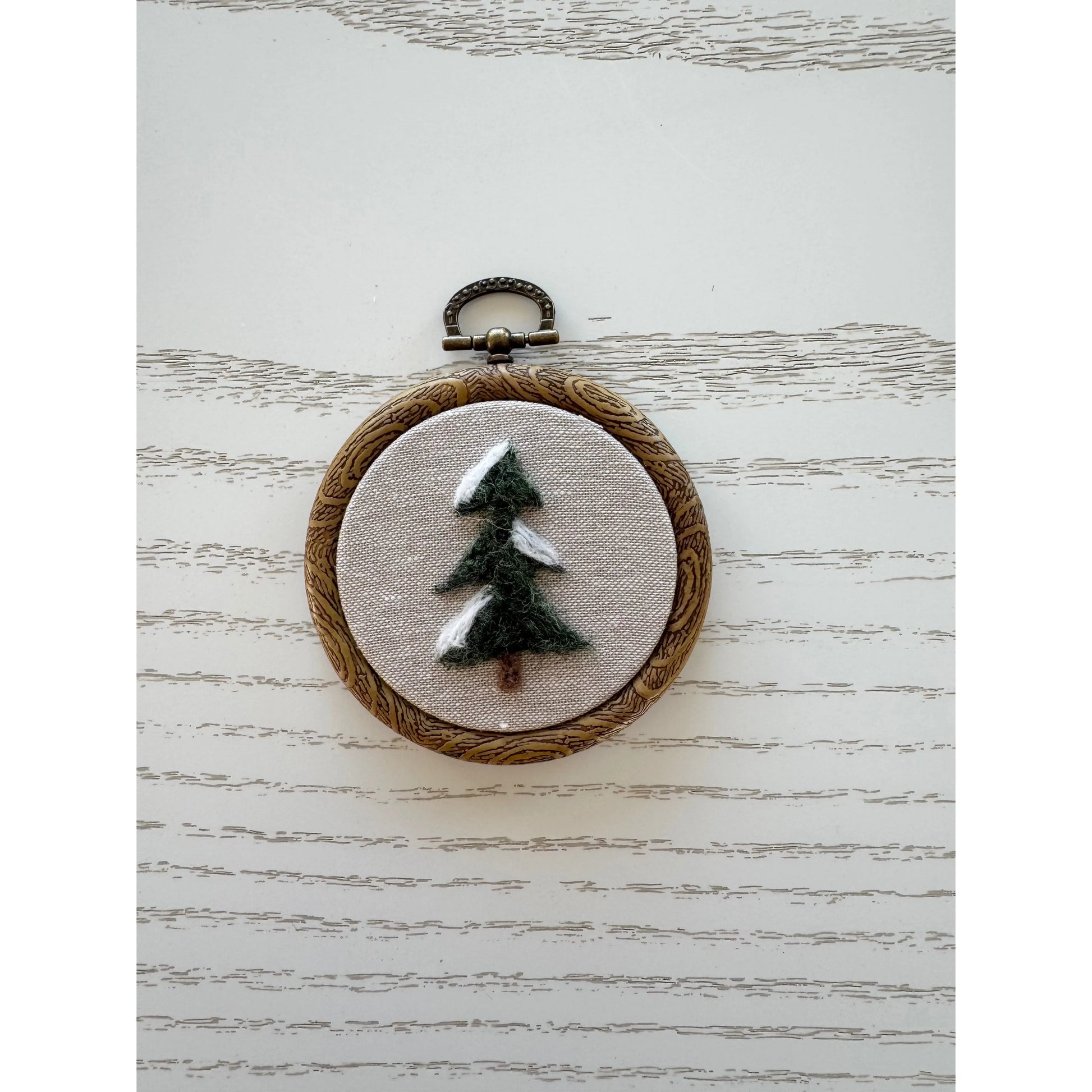 Embroidery hoop with a tree design on a textured white background