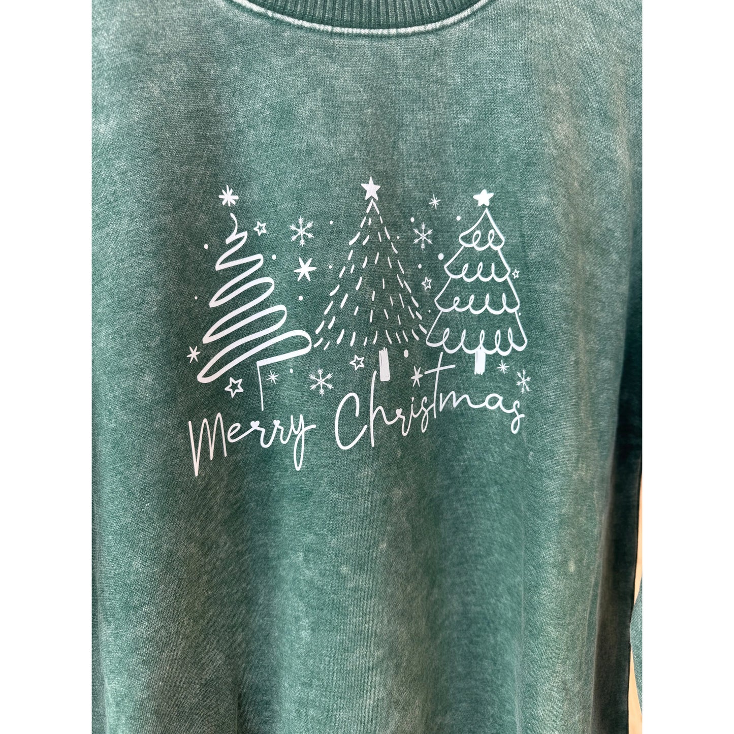 Green sweatshirt with white Christmas tree design and 'Merry Christmas' text on a white background