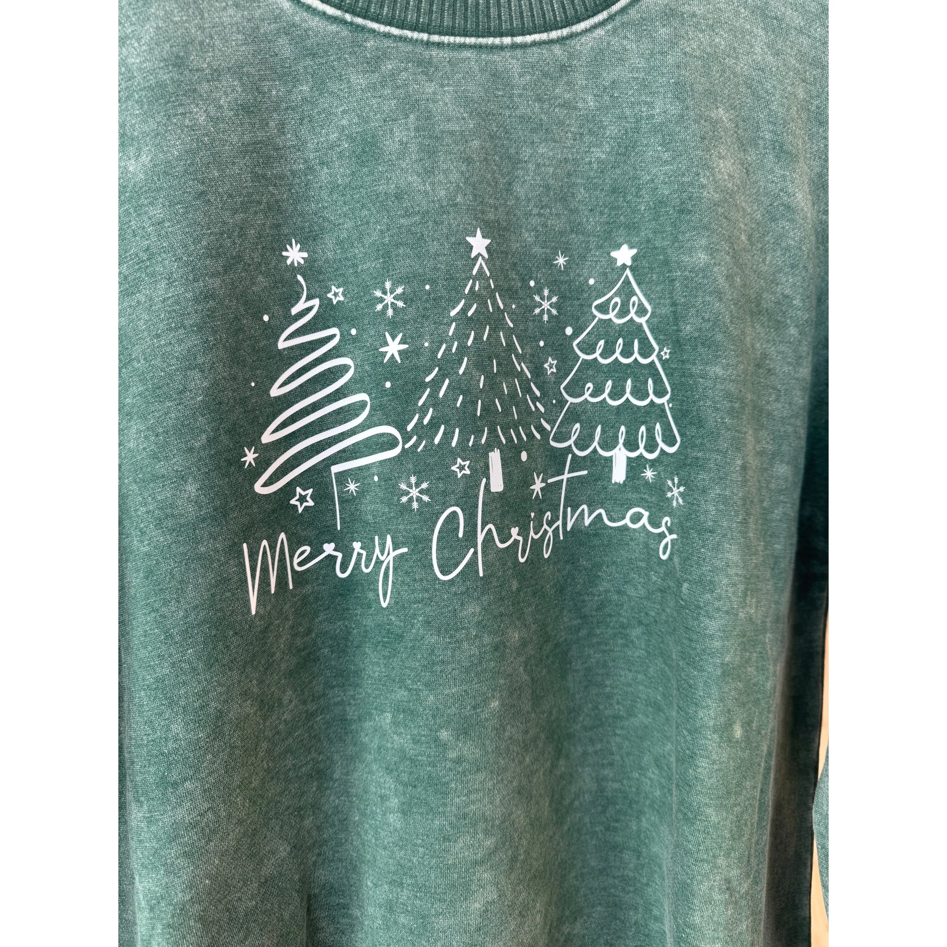 Green sweatshirt with white Christmas tree design and 'Merry Christmas' text on a white background