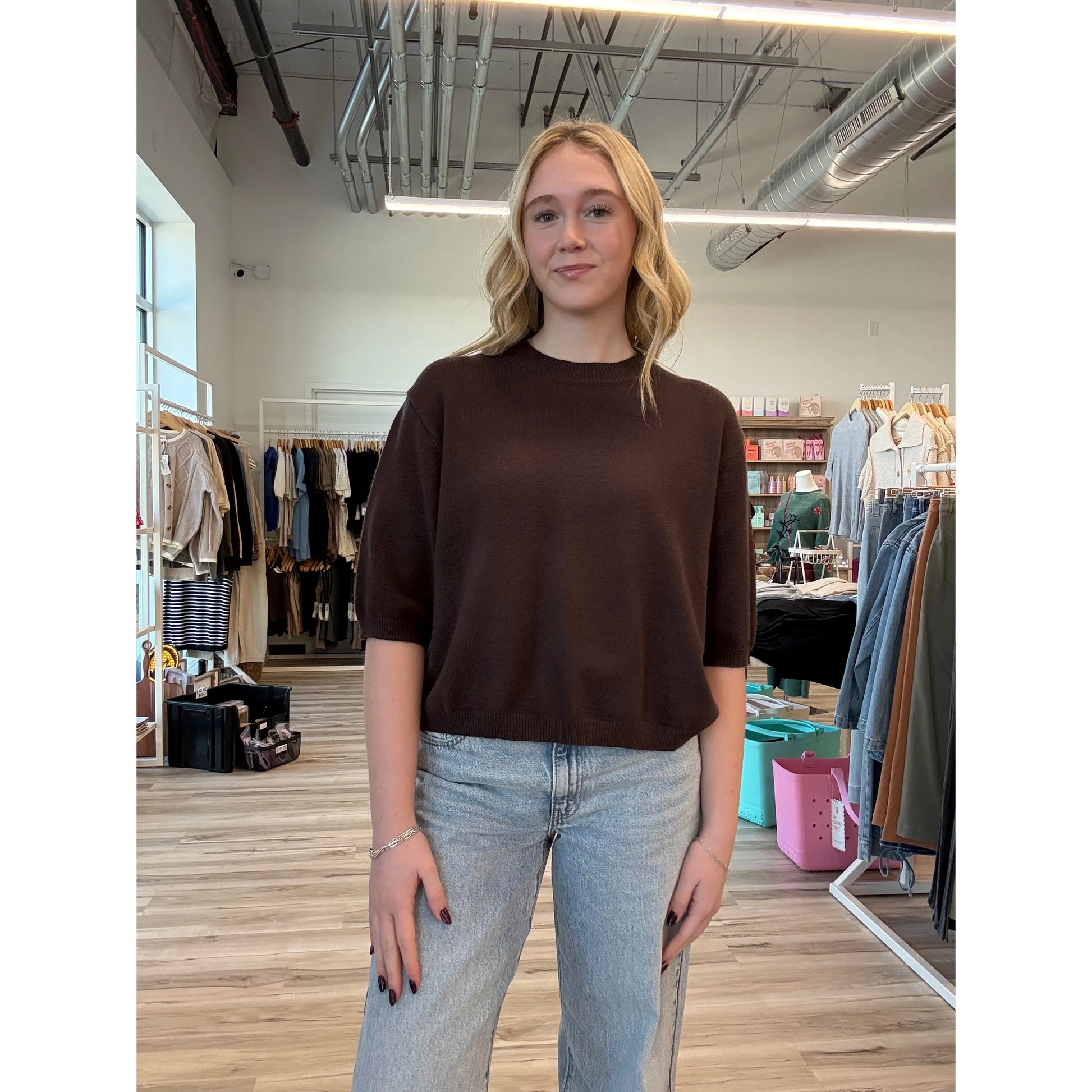 Woman wearing a short-sleeve brown knit top with a relaxed fit