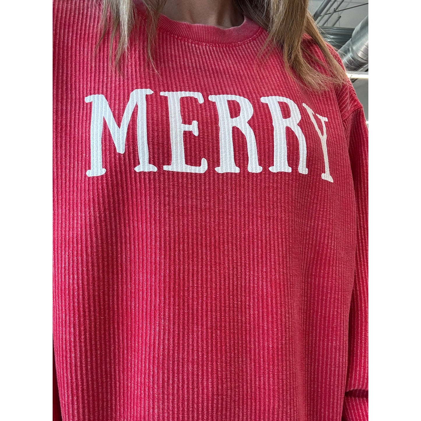 Red ribbed sweater with 'MERRY' text in white on a plain background worn by a person