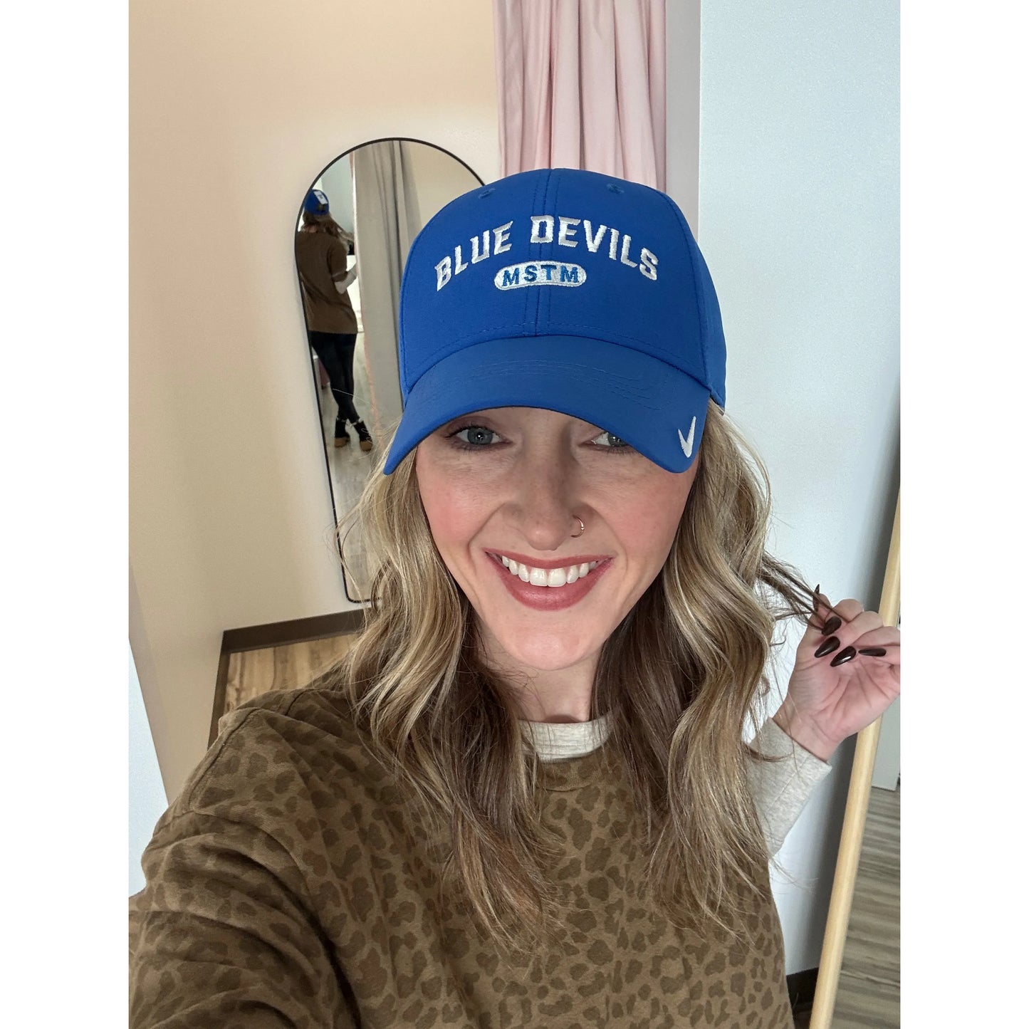 Person wearing a blue 'Blue Devils' cap indoors