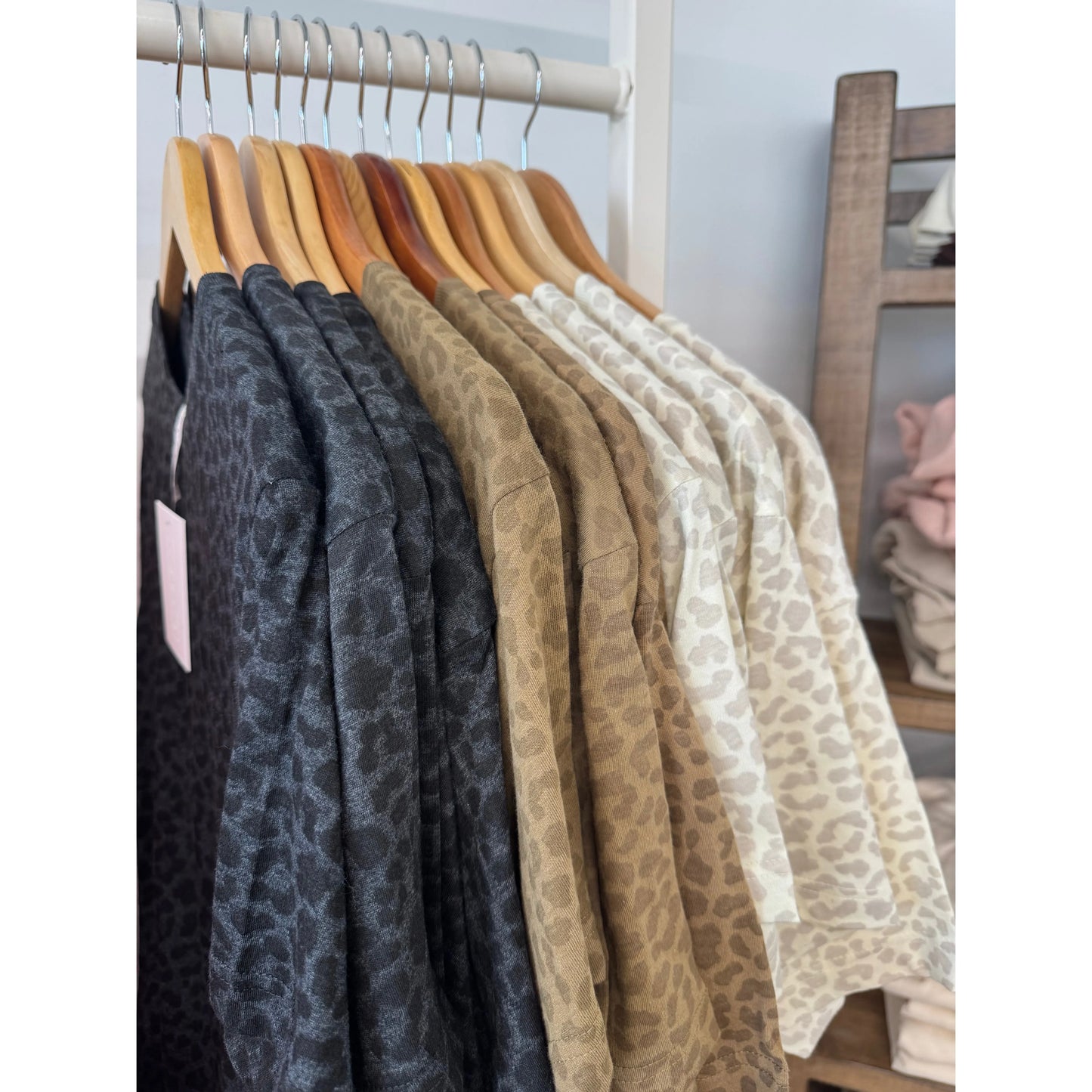 Hangers with leopard short-sleeve shirts in various colors on a rack.
