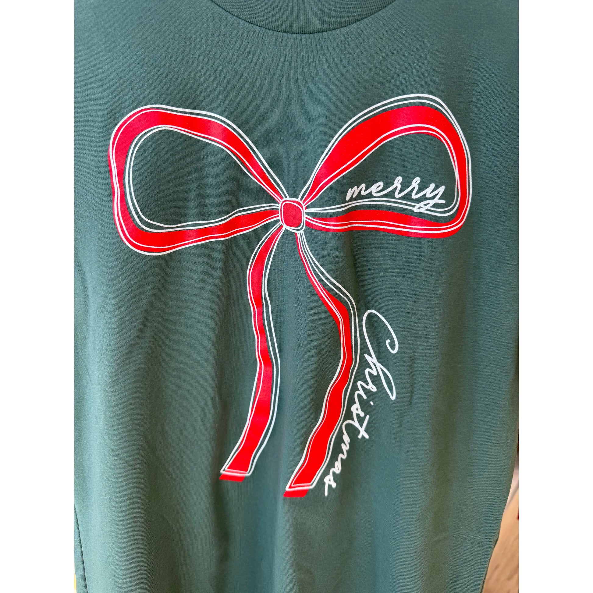 Green shirt with a red bow graphic and 'merry Christmas' text 