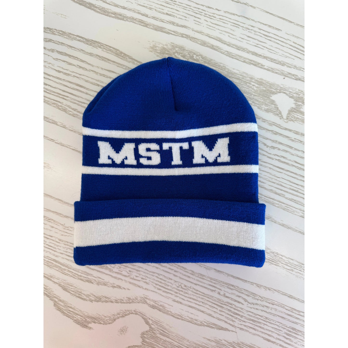 Blue knit beanie with white stripes and 'MSTM' logo