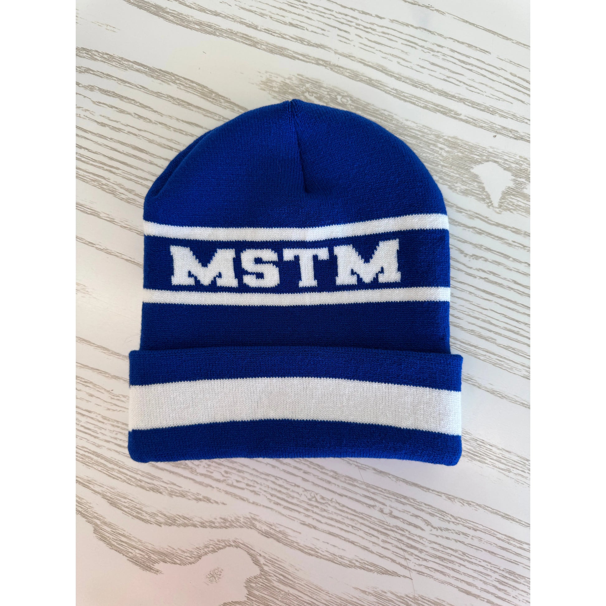 Blue knit beanie with white stripes and 'MSTM' logo