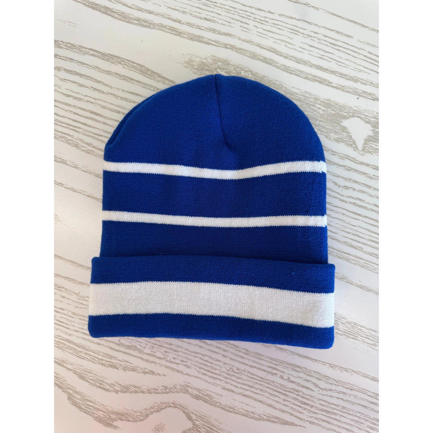 Blue and white striped beanie on a wooden surface