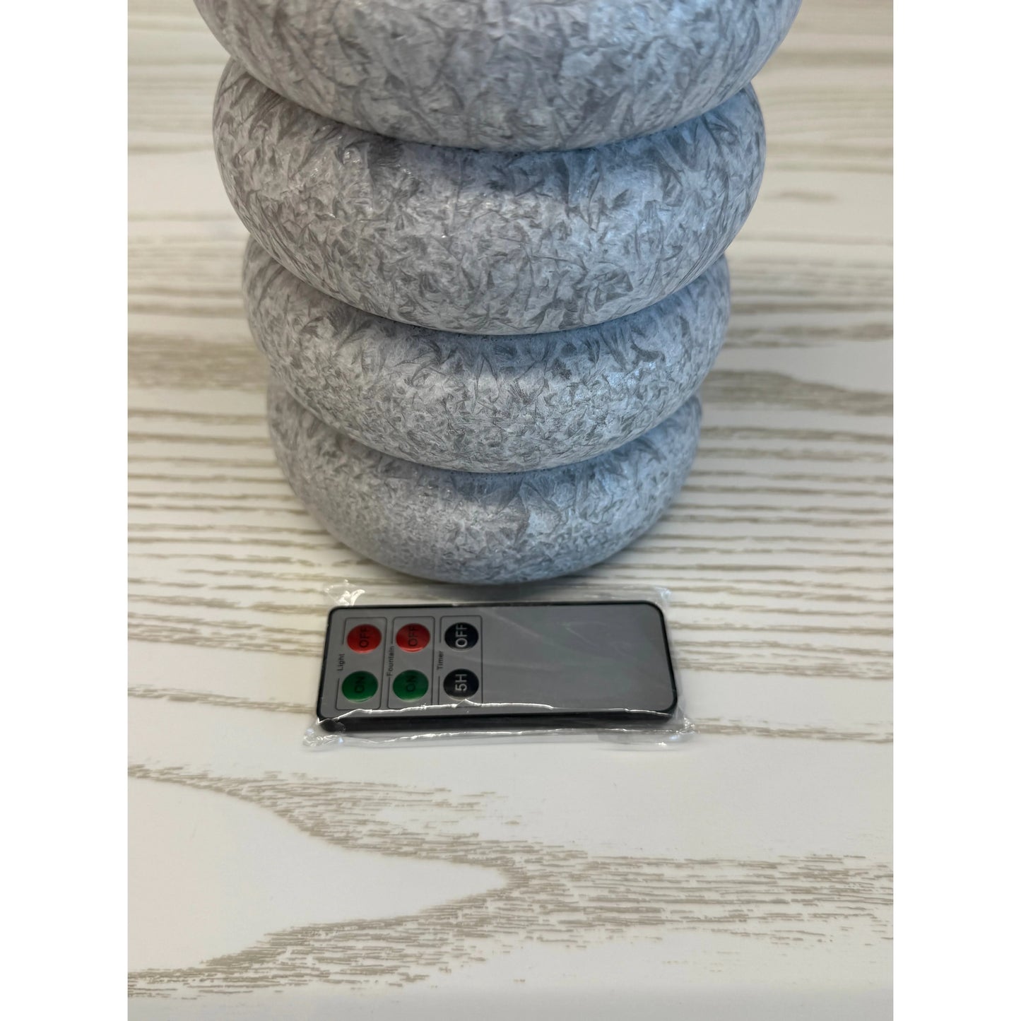 Stack of gray stones with a remote control for water fountain