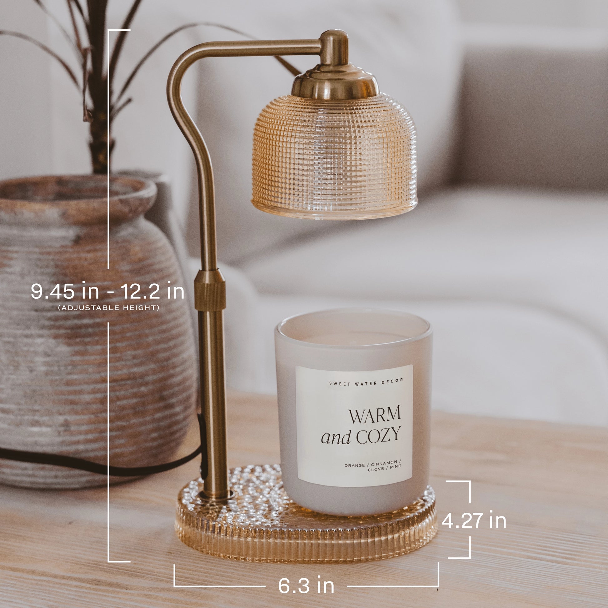 Decorative lamp with a candle labeled 'Warm and Cozy' on a wooden surface.
