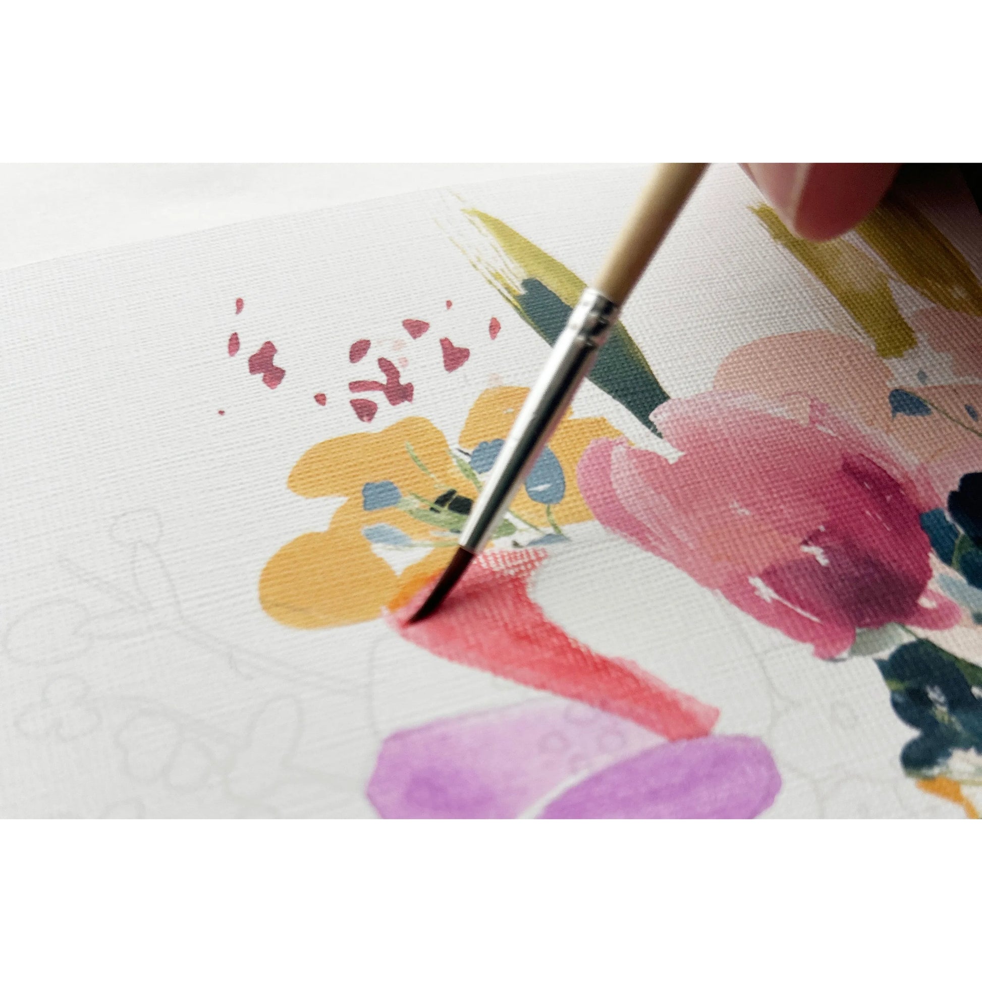 Paintbrush applying paint to a floral design on fabric