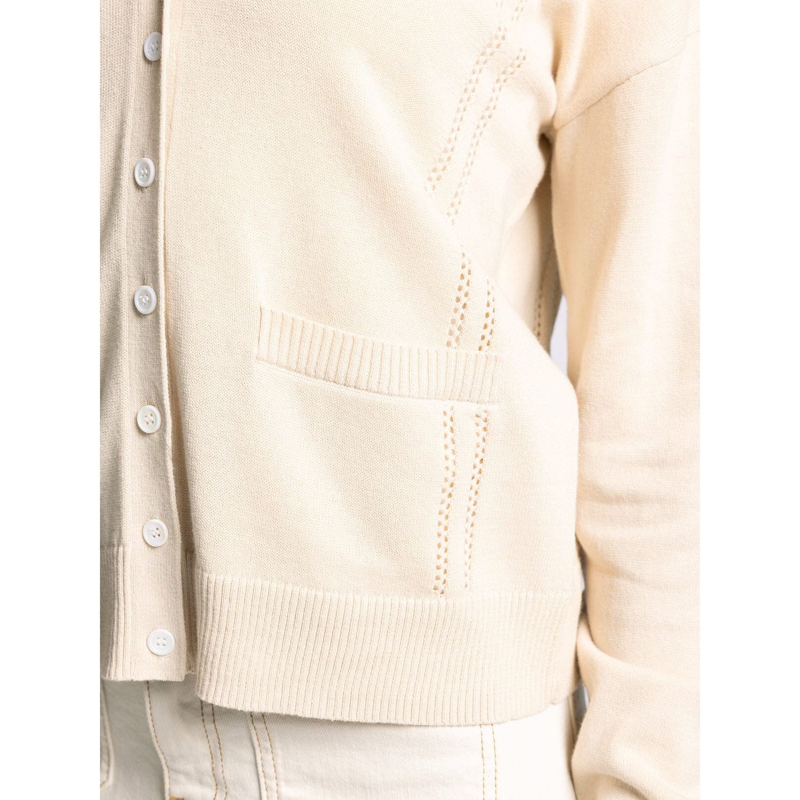 Close-up of a beige cardigan with button details on a white background