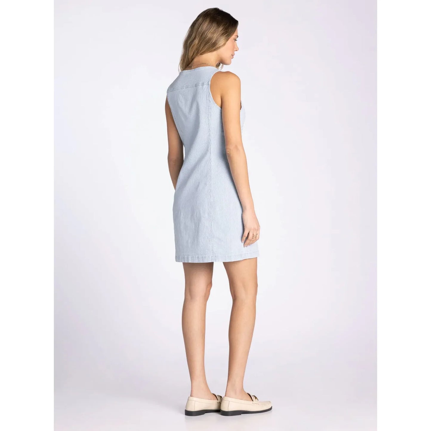 Woman wearing a light blue sleeveless dress.