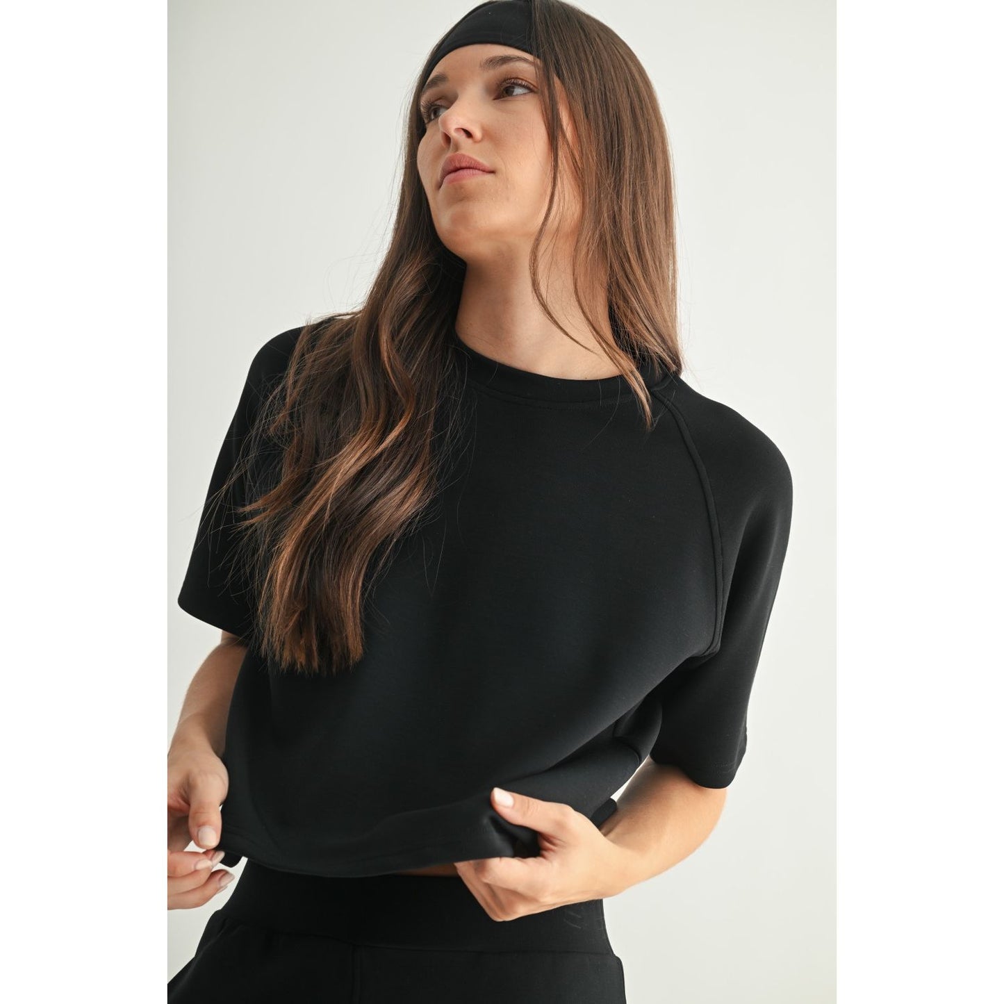 Woman wearing a black short sleeve tee against a white background