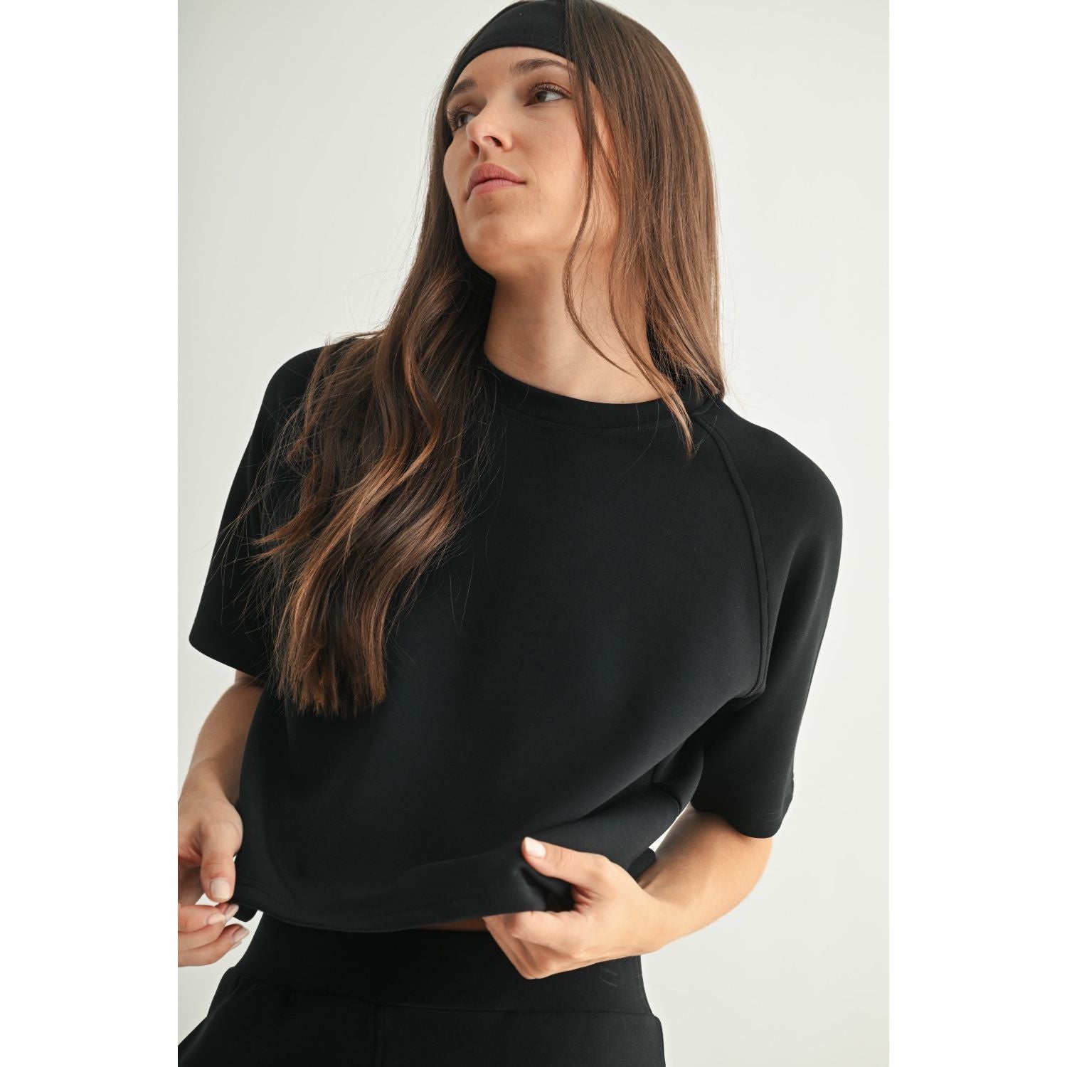 Woman wearing a black short sleeve tee against a white background